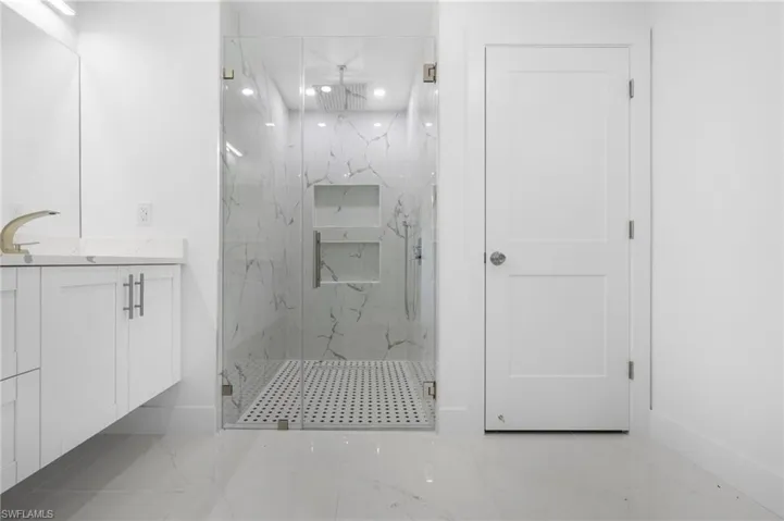 Bathroom with an enclosed shower and tile patterned floors