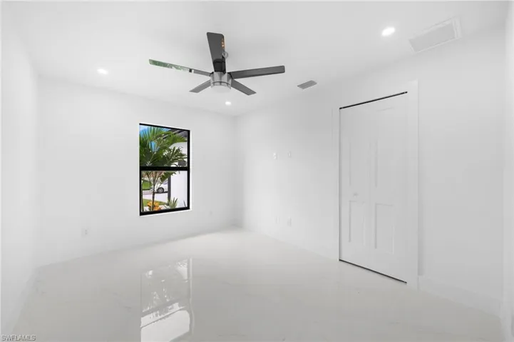 Empty room with tile patterned floors and ceiling fan