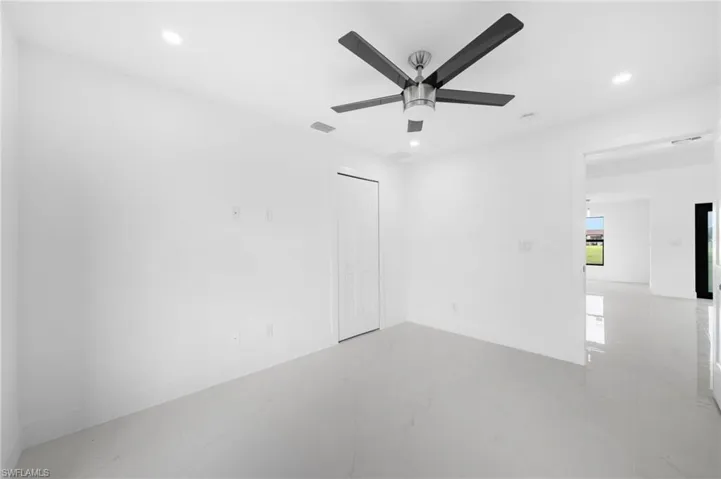 Tiled empty room featuring ceiling fan