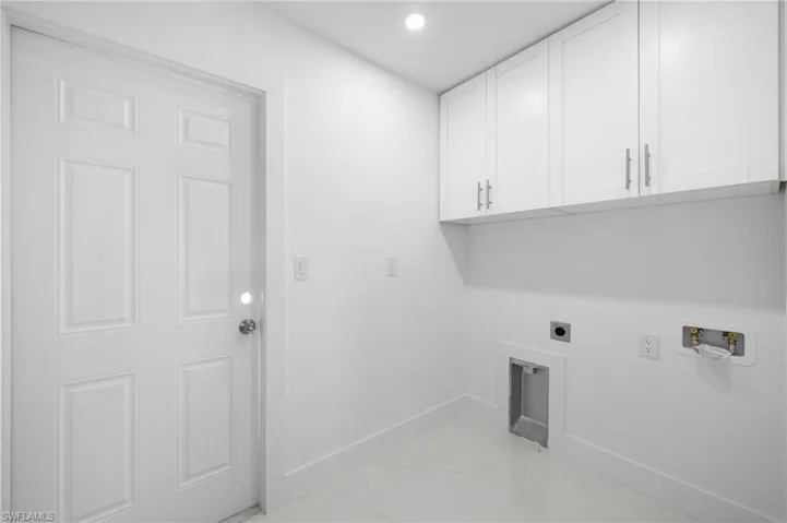 Washroom featuring electric dryer hookup, cabinets, hookup for a washing machine, and light tile patterned floors