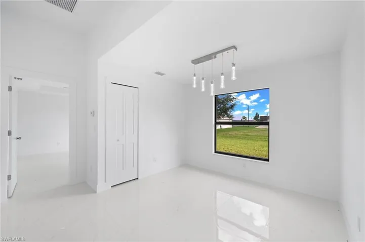 Unfurnished room with light tile patterned floors and track lighting