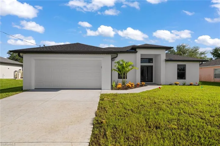 View of front facade featuring a garage and a front yard
