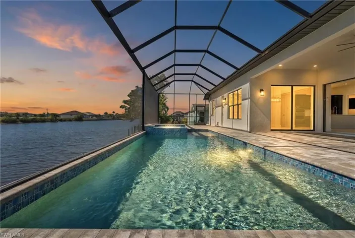 Relaxing pool / spa featuring a sunroom, a patio area, and a lanai