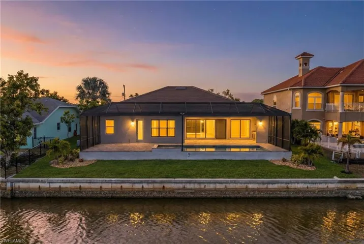 Rear view of house with a patio area, a water view, a fenced backyard, and a sunroom