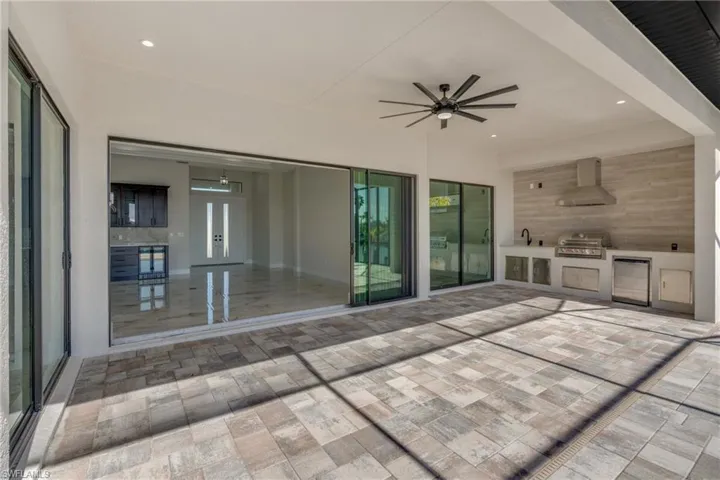 View of patio with area for grilling, ceiling fan, and french doors