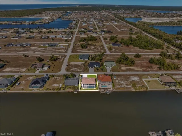 Aerial view of property's location featuring a nearby body of water and nearby suburban area