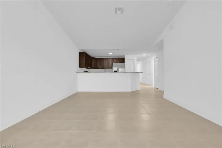 Unfurnished living room with light tile patterned flooring, recessed lighting, and lofted ceiling