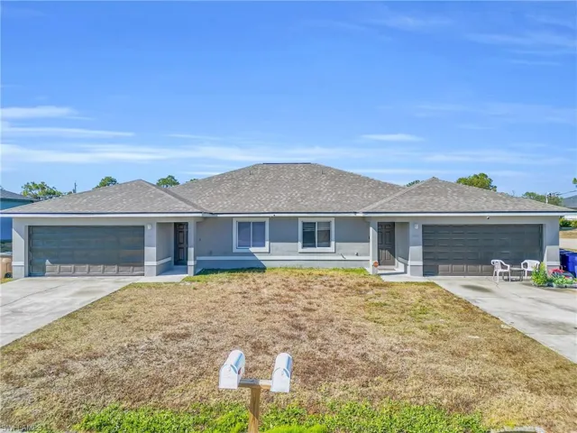 Ranch-style home featuring an attached garage, concrete driveway, and roof with shingles
