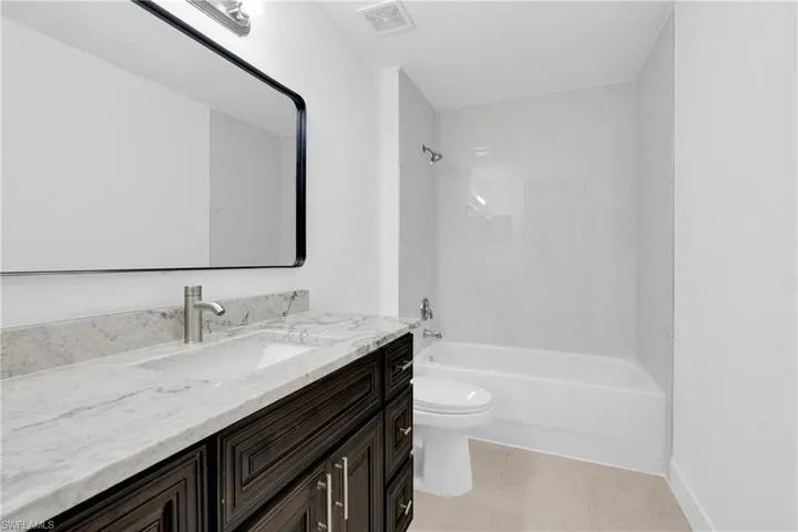 Full bath featuring vanity, shower / washtub combination, and light tile patterned floors