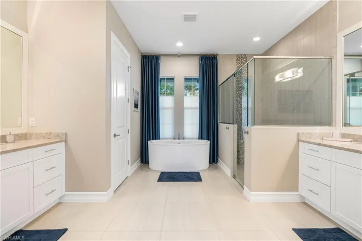 Bathroom featuring vanity and separate shower and tub