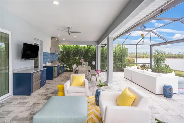 View of patio / terrace with ceiling fan, exterior kitchen, glass enclosure, grilling area, and an outdoor hangout area