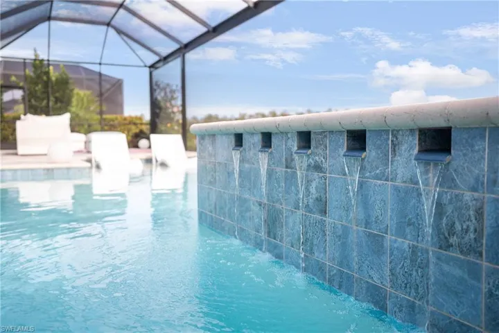 View of swimming pool featuring a lanai and pool water feature