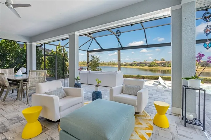 Sunroom / solarium featuring ceiling fan and a water view