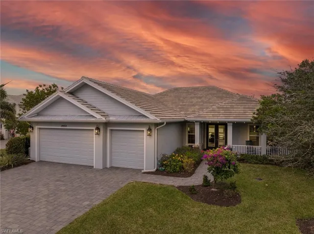 Ranch-style home featuring a garage and a lawn