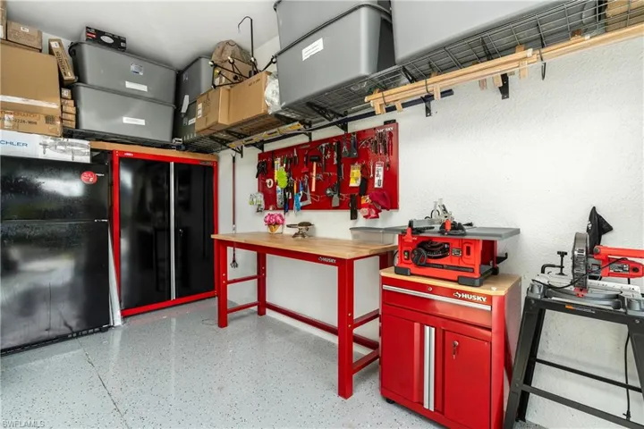 Garage featuring black refrigerator and a workshop area