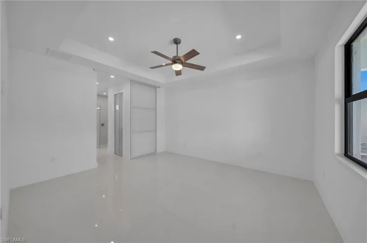 Unfurnished room with recessed lighting, a raised ceiling, marble finish floor, and ceiling fan