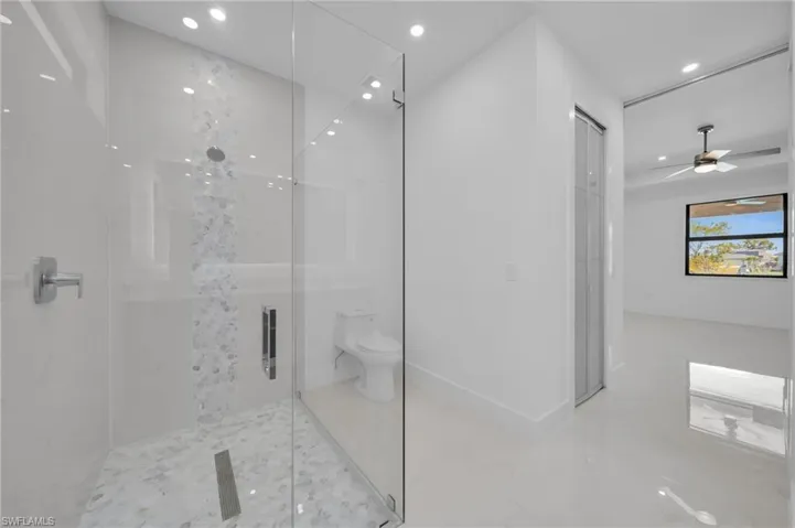 Full bath featuring recessed lighting, toilet, a stall shower, and a ceiling fan