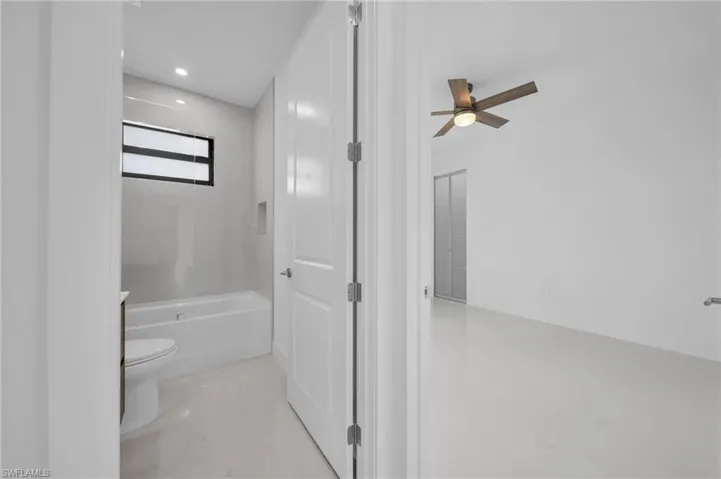 Bathroom featuring recessed lighting, marble finish floor, toilet, a bathtub, and ceiling fan