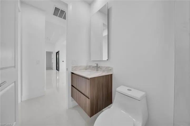 Bathroom with visible vents, toilet, and vanity