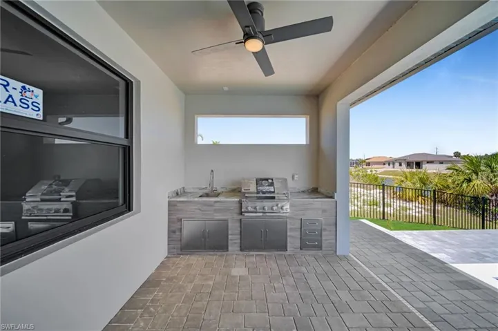View of patio / terrace with fence, a ceiling fan, a sink, and area for grilling