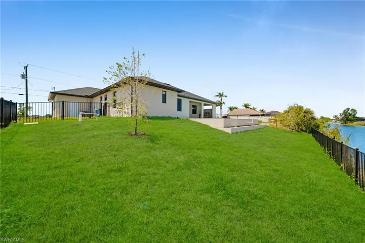 Back of property featuring a fenced backyard, a patio area, a yard, and stucco siding