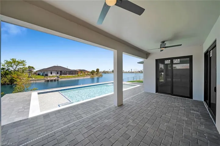 Pool featuring a water view, a patio area, and ceiling fan