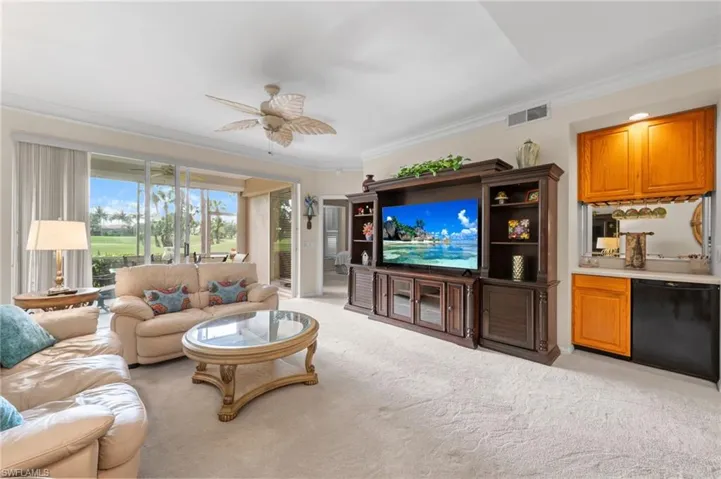 Living room featuring ornamental molding, light carpet, and ceiling fan