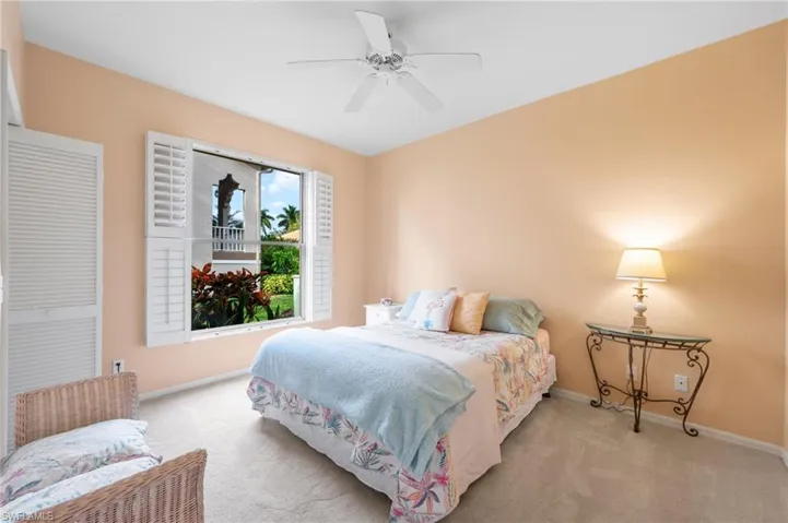 Carpeted bedroom featuring baseboards and a ceiling fan