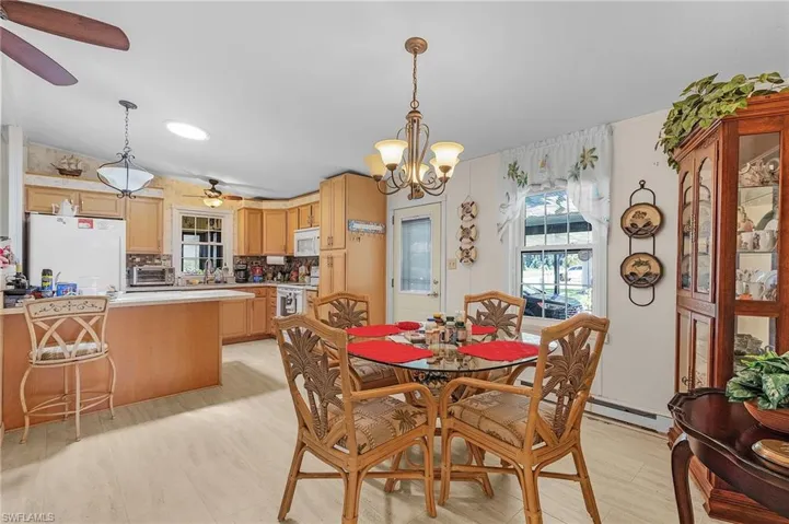 Dining space featuring ceiling fan with notable chandelier and baseboard heating