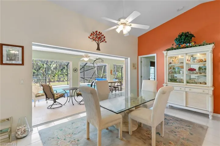 Dining space featuring a sunroom, a ceiling fan, lofted ceiling, and light tile patterned floors