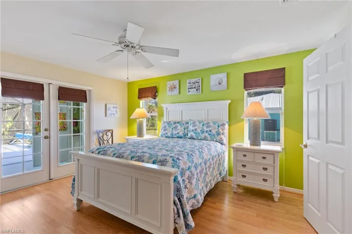 Bedroom featuring light wood-style flooring, access to outside, multiple windows, and ceiling fan