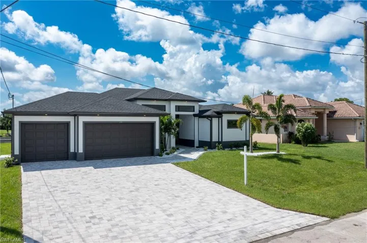 View of front facade featuring a front yard and a garage