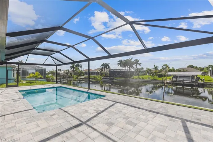 View of swimming pool featuring a water view, a patio, and screened enclosure