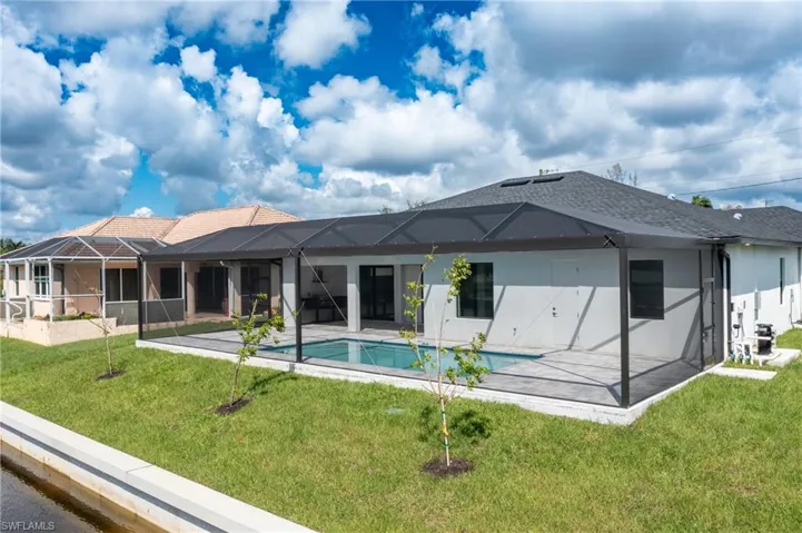 Back of property featuring a yard, Screened enclosure, and a patio