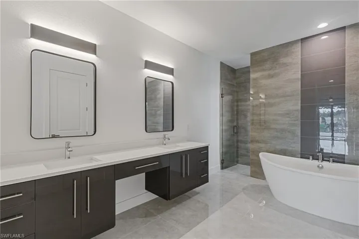Bathroom featuring vanity and separate shower and tub