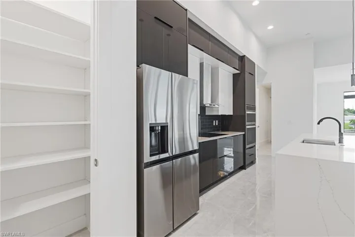 Kitchen featuring pendant lighting, stainless steel appliances, backsplash, and sink