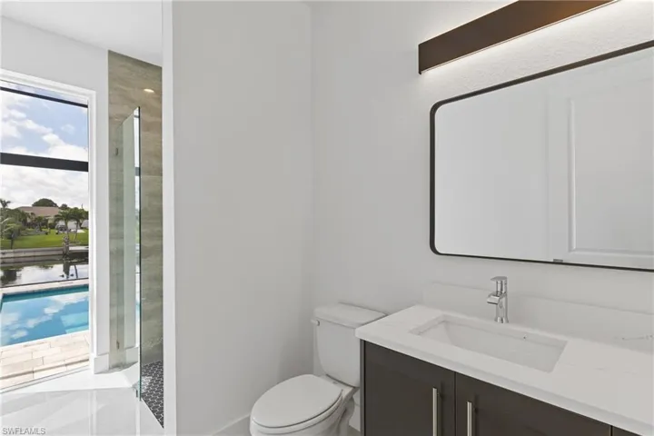 Bathroom with walk in shower, vanity, toilet, and tile patterned floors