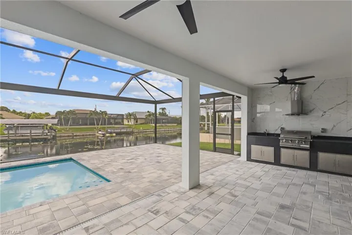 View of pool featuring ceiling fan, area for grilling, screened enclosure, and a patio area