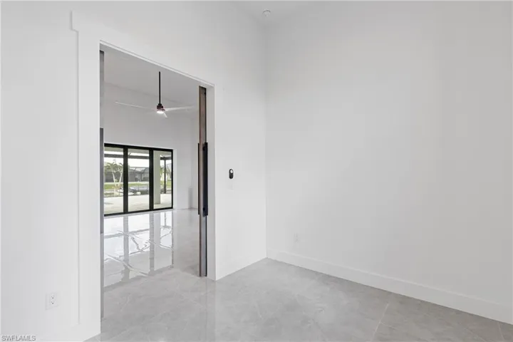 Tiled empty room featuring a towering ceiling and ceiling fan