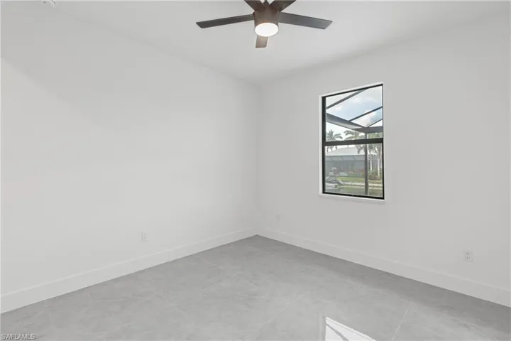 Empty room with light tile patterned floors and ceiling fan