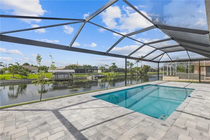 View of pool featuring a patio, screened enclosure, and a water view
