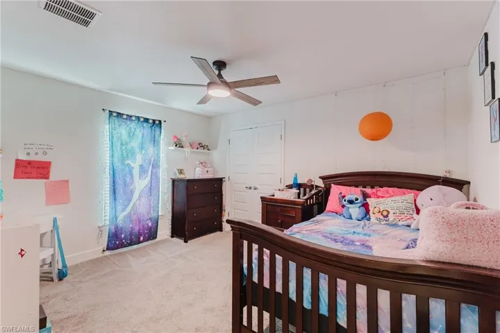 Bedroom featuring a closet, light colored carpet, and ceiling fan