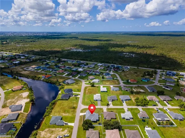 Aerial view of property and surrounding area with nearby suburban area