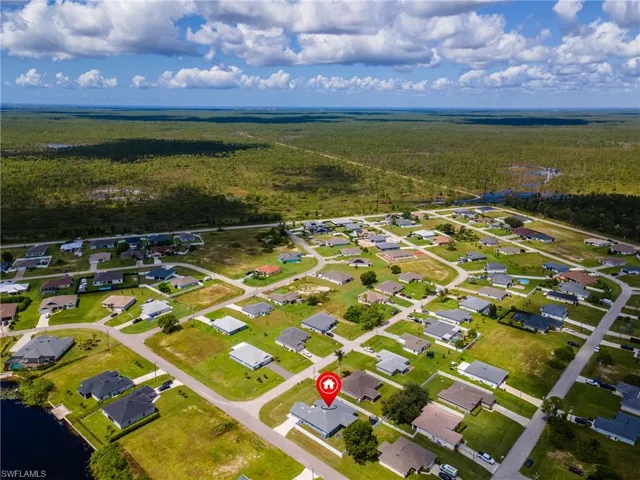 Aerial view of property and surrounding area with nearby suburban area