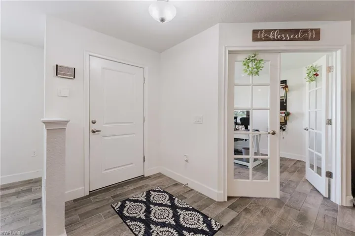Foyer with french doors and light wood-style flooring