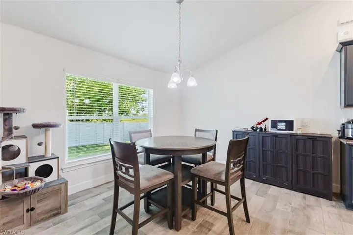 Dining room featuring light wood finished floors, lofted ceiling, and a chandelier