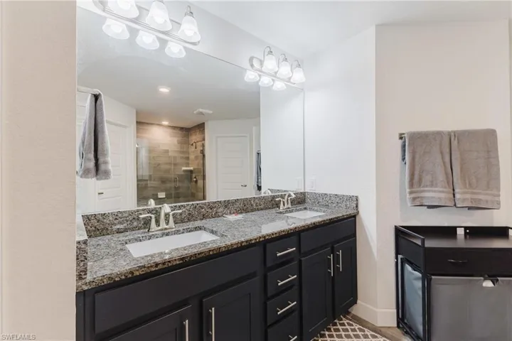 Full bathroom with double vanity and a stall shower