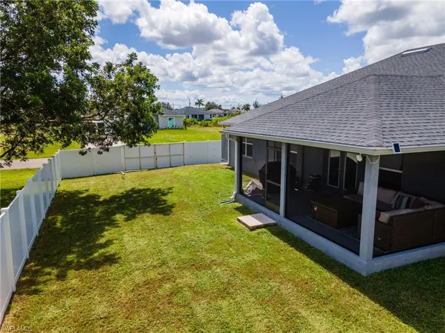 Fenced backyard featuring a sunroom and a residential view