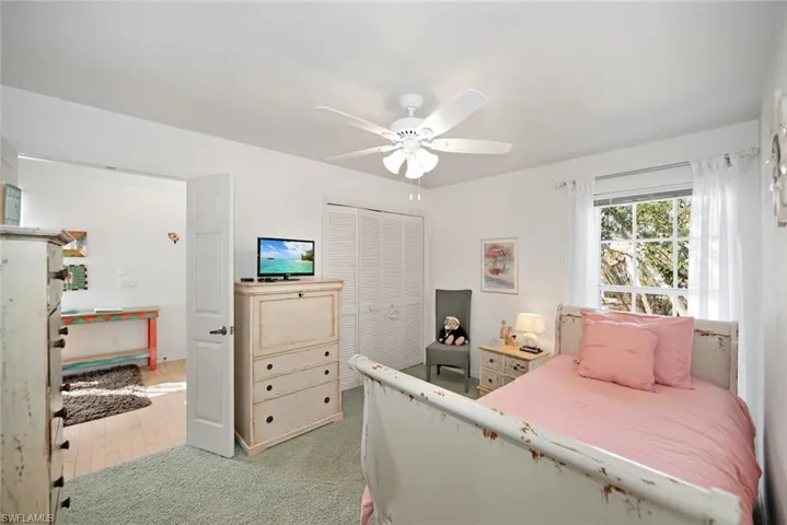Bedroom with ceiling fan, wood-type flooring, and a closet