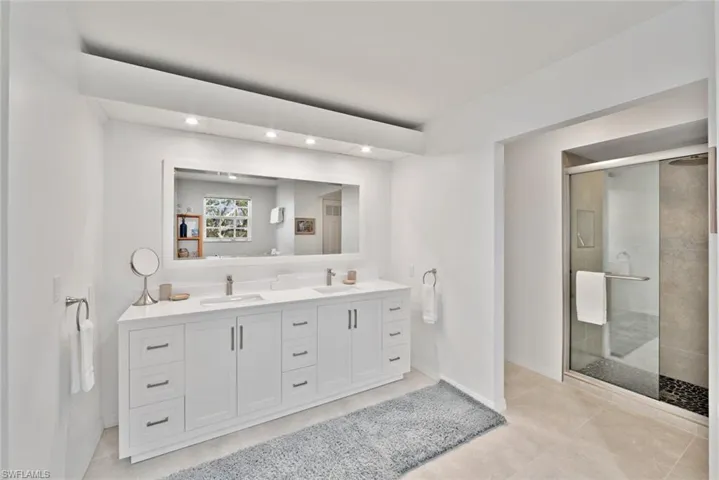 Bathroom with tile patterned flooring, vanity, and an enclosed shower